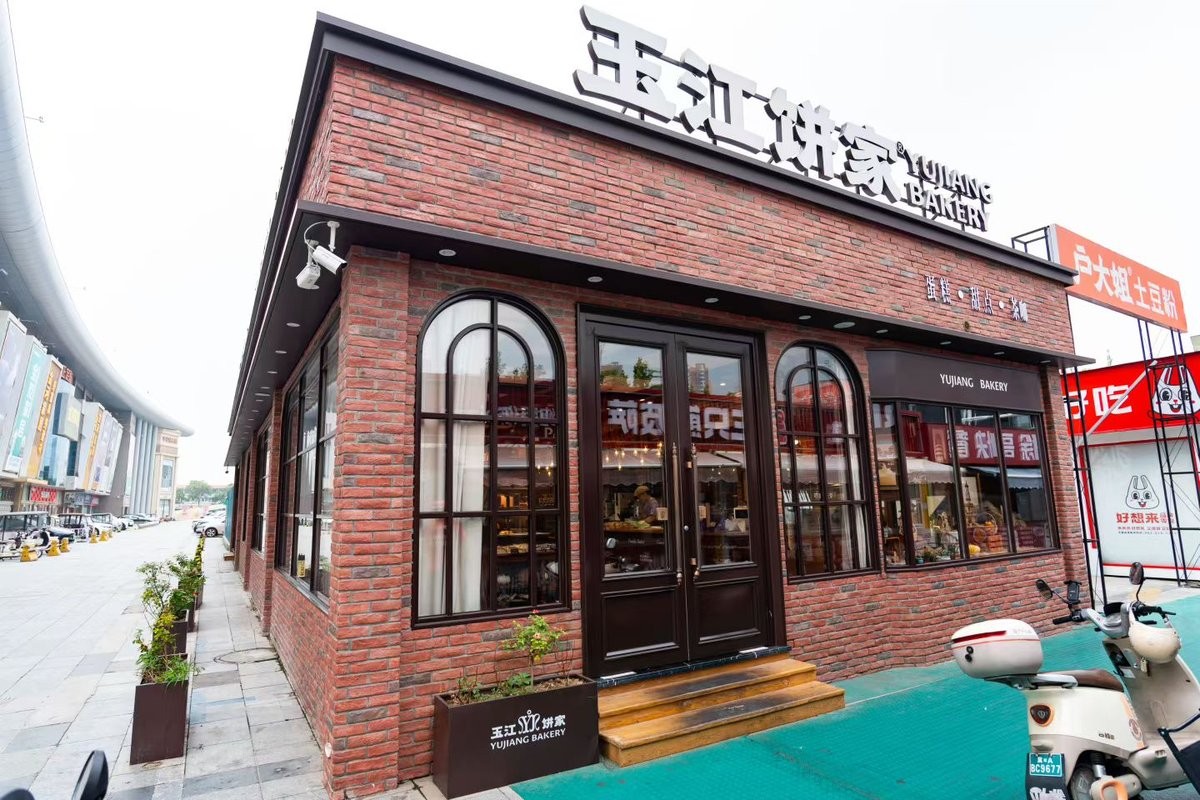 玉江饼家红砖转角拱形窗与木框玻璃门外观